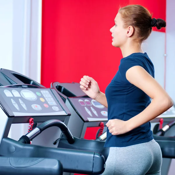 Jovem mulher no ginásio correr em uma máquina — Fotografia de Stock