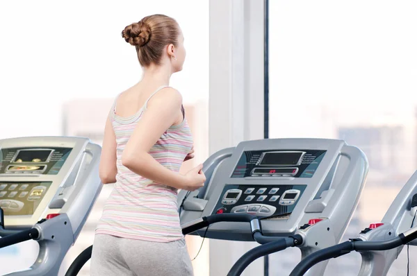 Vrouw op gym uitoefening. draaien op machine — Stockfoto