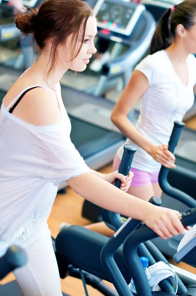 Two young sporty women run on machine — Stock Photo, Image