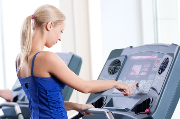 Zwei junge Frauen laufen im Fitnessstudio an einem Gerät — Stockfoto