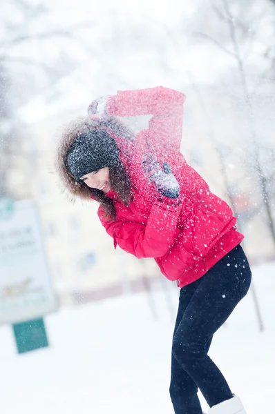 Lycklig ung kvinna leker med en snö — Stockfoto