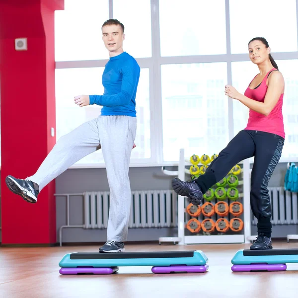 Hombre y mujer en el gimnasio haciendo estiramiento —  Fotos de Stock