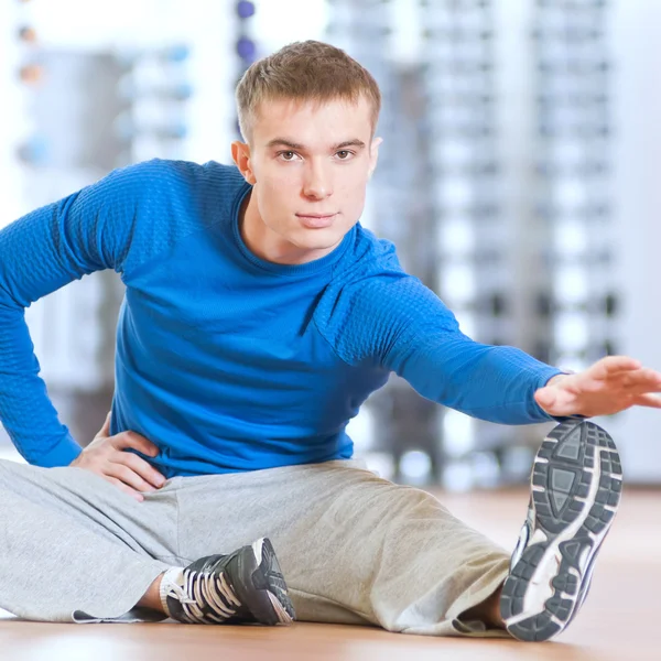 Man doing stretching exercises at the gym — Stock Photo, Image