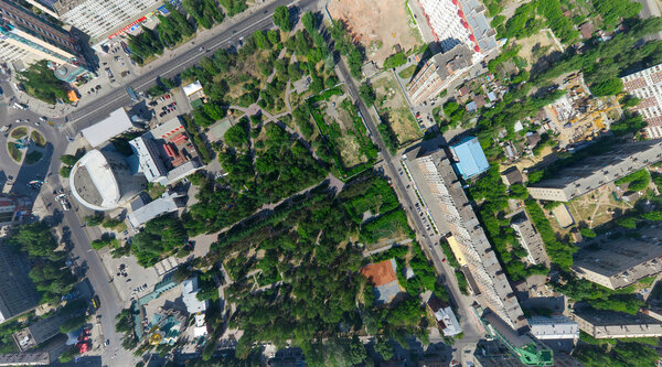Aerial city view with crossroads, roads, houses, parks, parking lots, bridges