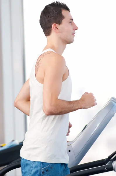 Hombre en el gimnasio haciendo ejercicio. Corre. . —  Fotos de Stock