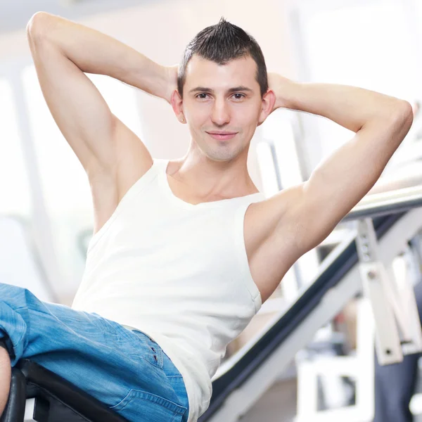 Young man doing exercises at gym — Stock Photo, Image