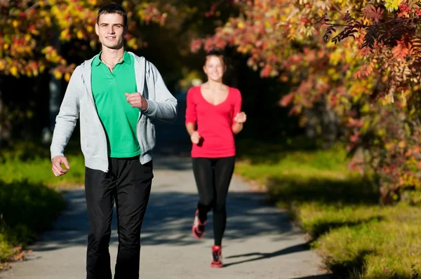 Joven hombre y mujer corriendo — Foto de Stock