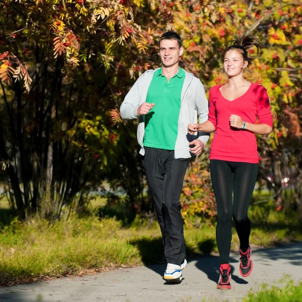 Joven hombre y mujer corriendo — Foto de Stock