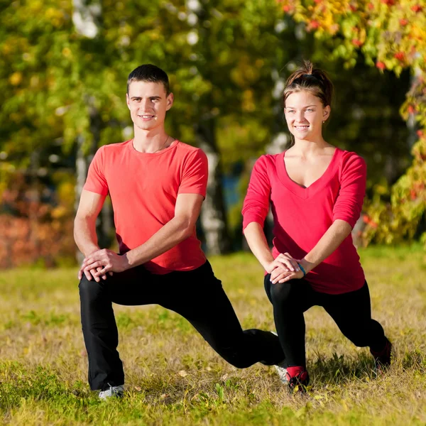 男人和女人的女人，在公园做瑜伽 — 图库照片