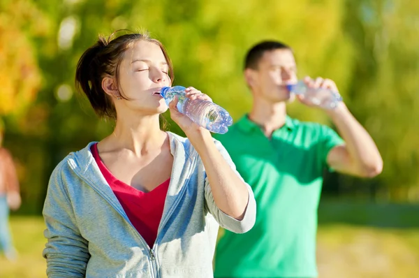 Mann und Frau trinken aus Flasche — Stockfoto