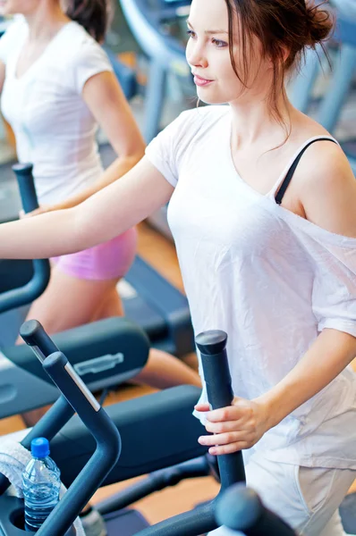 Two young sporty women run on machine — Stock Photo, Image