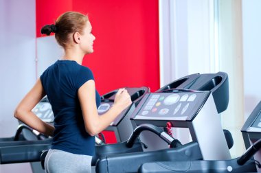 spor salonunda bir makinede çalışan genç bir kadın