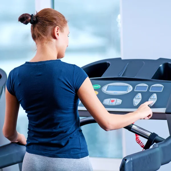 Giovane donna in palestra correre su una macchina — Foto Stock