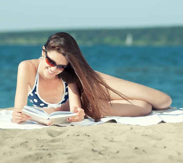 海岸で本を読んでいる女性は — ストック写真