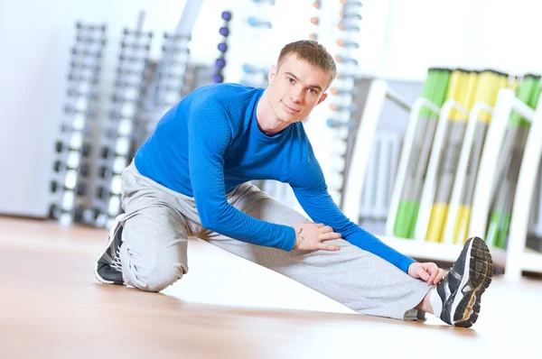 Hombre haciendo ejercicios de estiramiento en el gimnasio —  Fotos de Stock