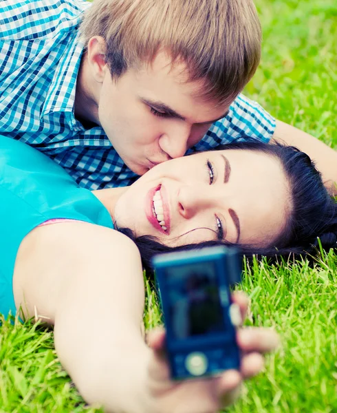 Happy teenage couple taking picture — Stock Photo, Image