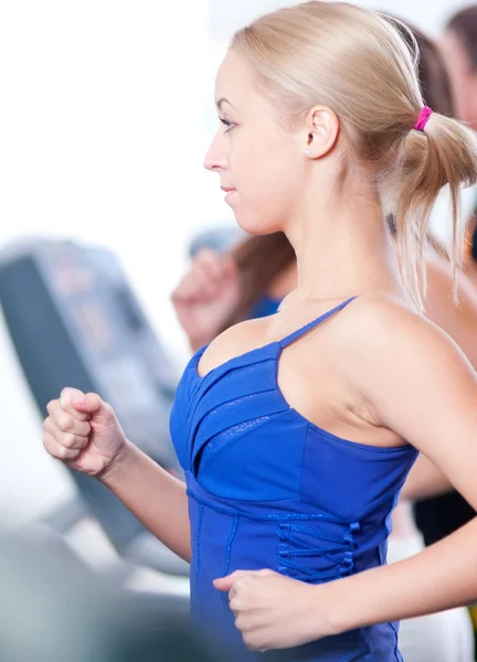 Två unga kvinnor köra på maskin i gymmet — Stockfoto