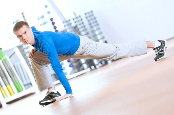 Uomo che fa esercizi di stretching in palestra — Foto Stock