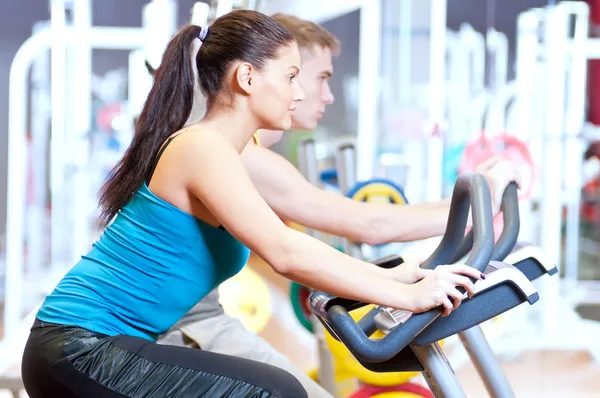 En el gimnasio haciendo entrenamiento de ciclismo cardiovascular — Foto de Stock