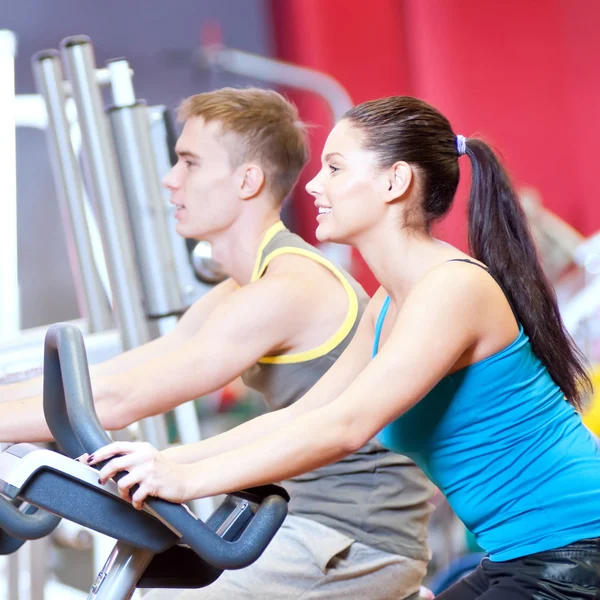 En el gimnasio haciendo entrenamiento de ciclismo cardiovascular — Foto de Stock