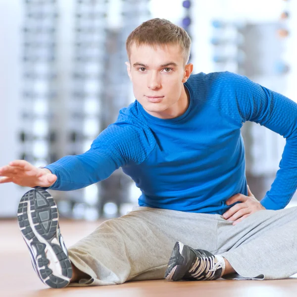Мужчина делает упражнения на растяжку в спортзале — стоковое фото