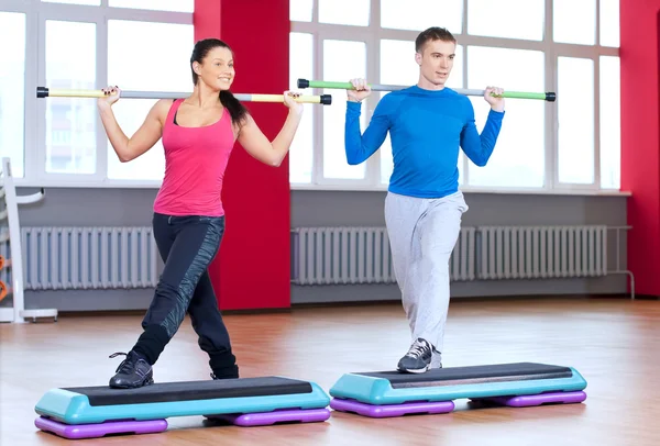 Uomo e donna in palestra facendo stretching — Foto Stock