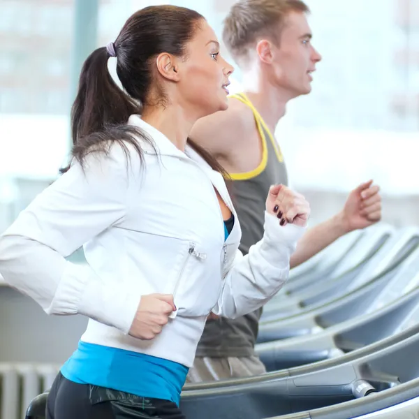 Wanita dan pria di gym berolahraga — Stok Foto