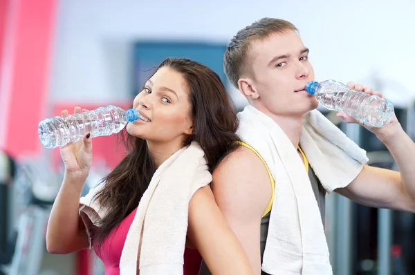 Hombre y mujer bebiendo agua después de los deportes — Foto de Stock