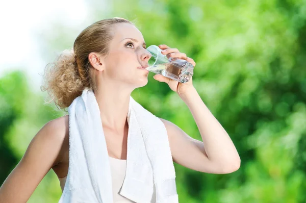 Mujer bebiendo agua después del ejercicio — Foto de Stock