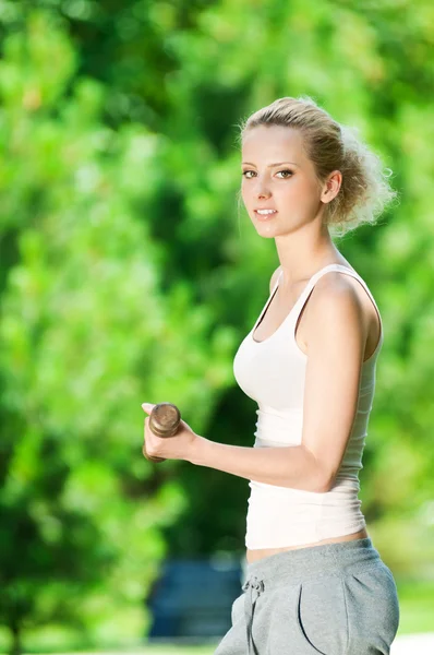 Vrouw doen halter oefening buiten — Stockfoto