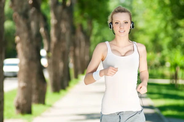 Young woman running in green park — Stock Photo, Image