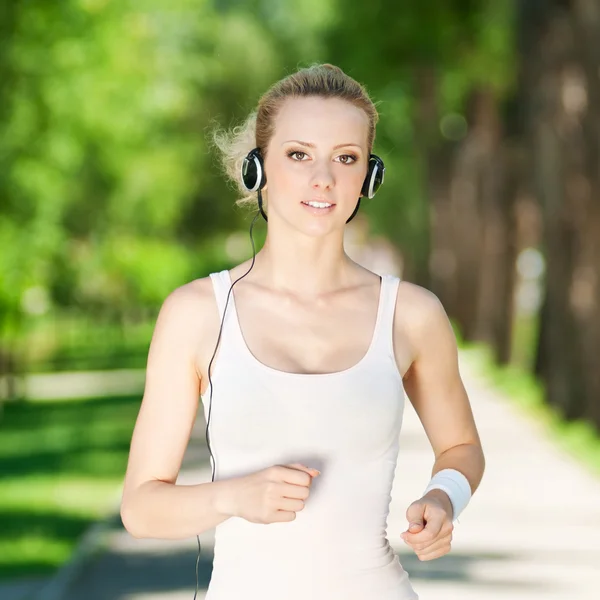 Mujer joven corriendo en el parque verde — Foto de Stock