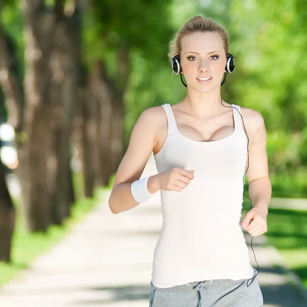 Mujer joven corriendo en el parque verde —  Fotos de Stock