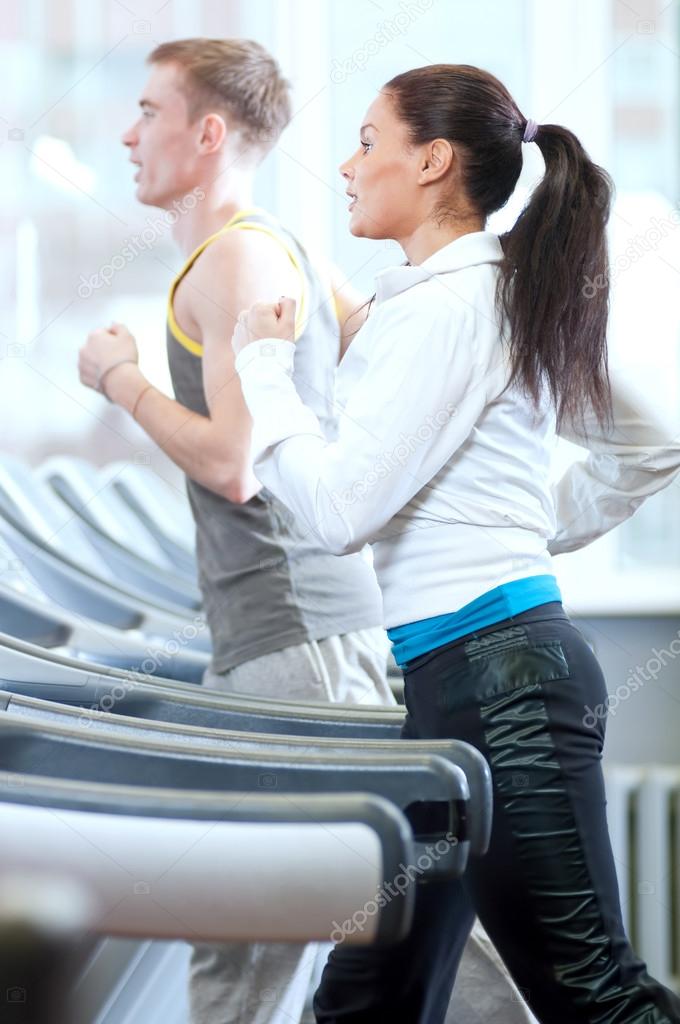 Woman and man at the gym exercising