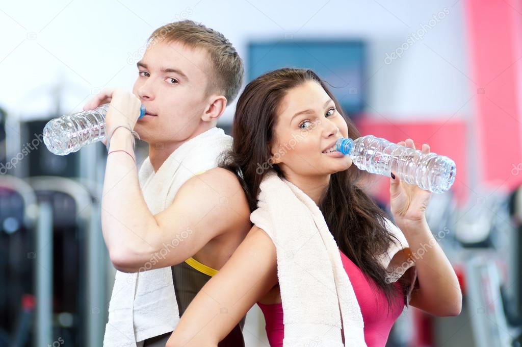 Man and woman drinking water after sports