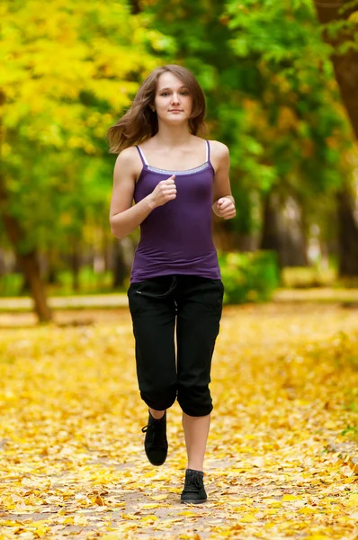 Une jeune fille qui court dans le parc d'automne — Photo