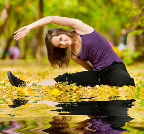 Frau macht Yoga-Übungen im Herbstpark — Stockfoto