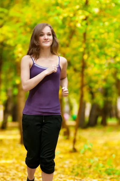 Ein junges Mädchen läuft im Herbstpark — Stockfoto