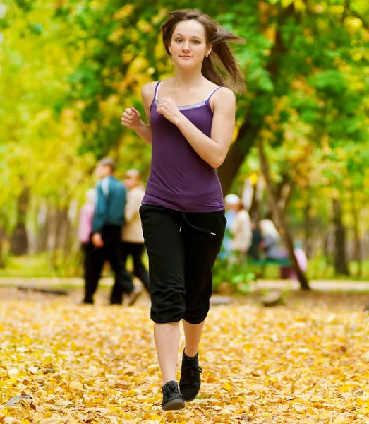 Una joven corriendo en el parque de otoño —  Fotos de Stock