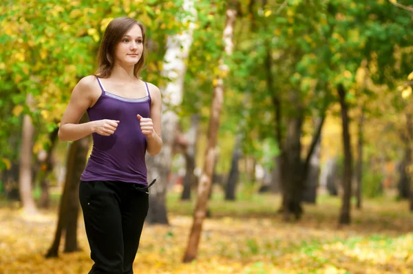 Una joven corriendo en el parque de otoño —  Fotos de Stock