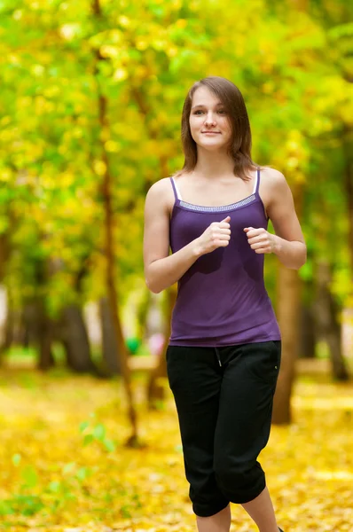 Una joven corriendo en el parque de otoño —  Fotos de Stock