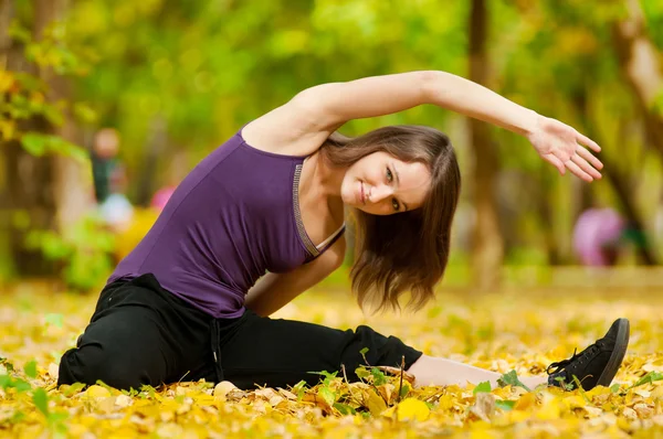 Mujer haciendo ejercicios de yoga en el parque de otoño — Foto de Stock