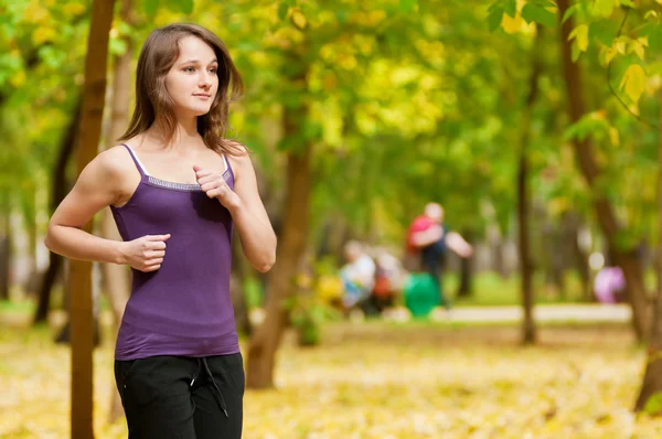 Una joven corriendo en el parque de otoño —  Fotos de Stock