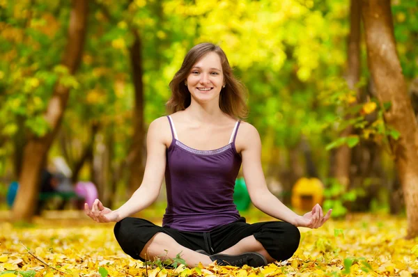 Donna che fa esercizi di yoga nel parco autunnale — Foto Stock