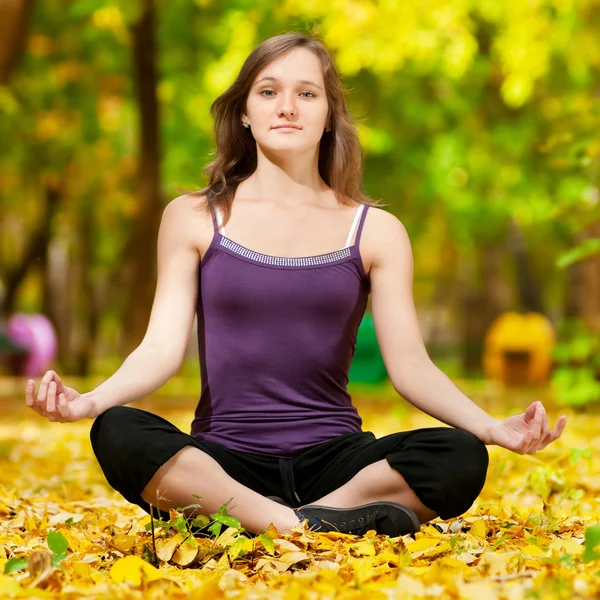 Donna che fa esercizi di yoga nel parco autunnale — Foto Stock