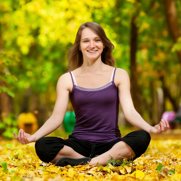 Frau macht Yoga-Übungen im Herbstpark — Stockfoto