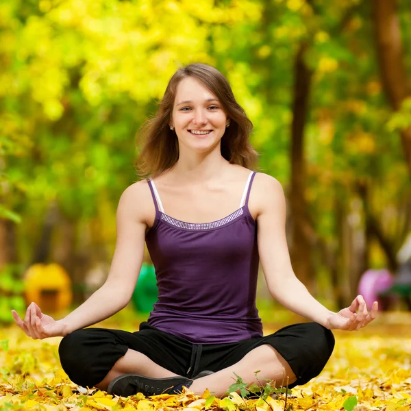 女人在做瑜伽锻炼在秋天的公园 — 图库照片