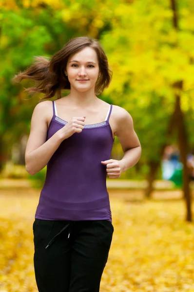 Una joven corriendo en el parque de otoño — Foto de Stock