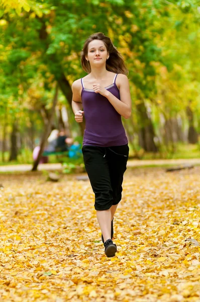 ローラー スケート公園で女性一个年轻的女孩在秋天公园中运行 — 图库照片