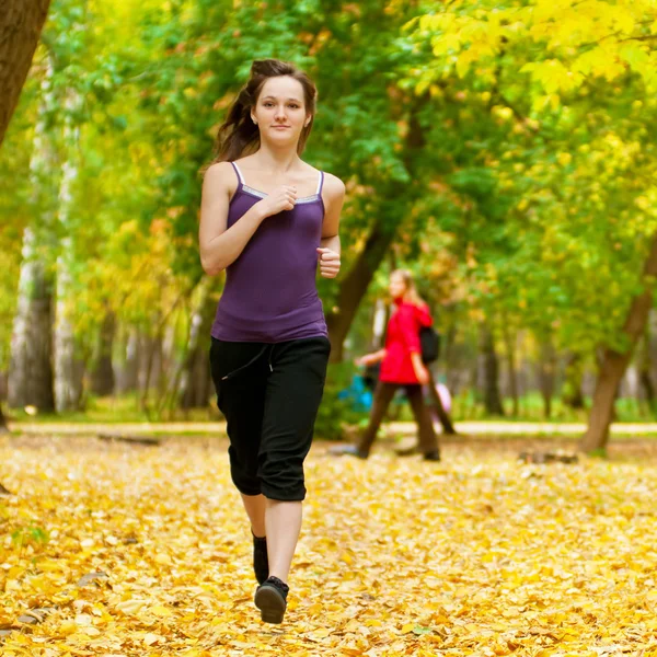 Una joven corriendo en el parque de otoño —  Fotos de Stock